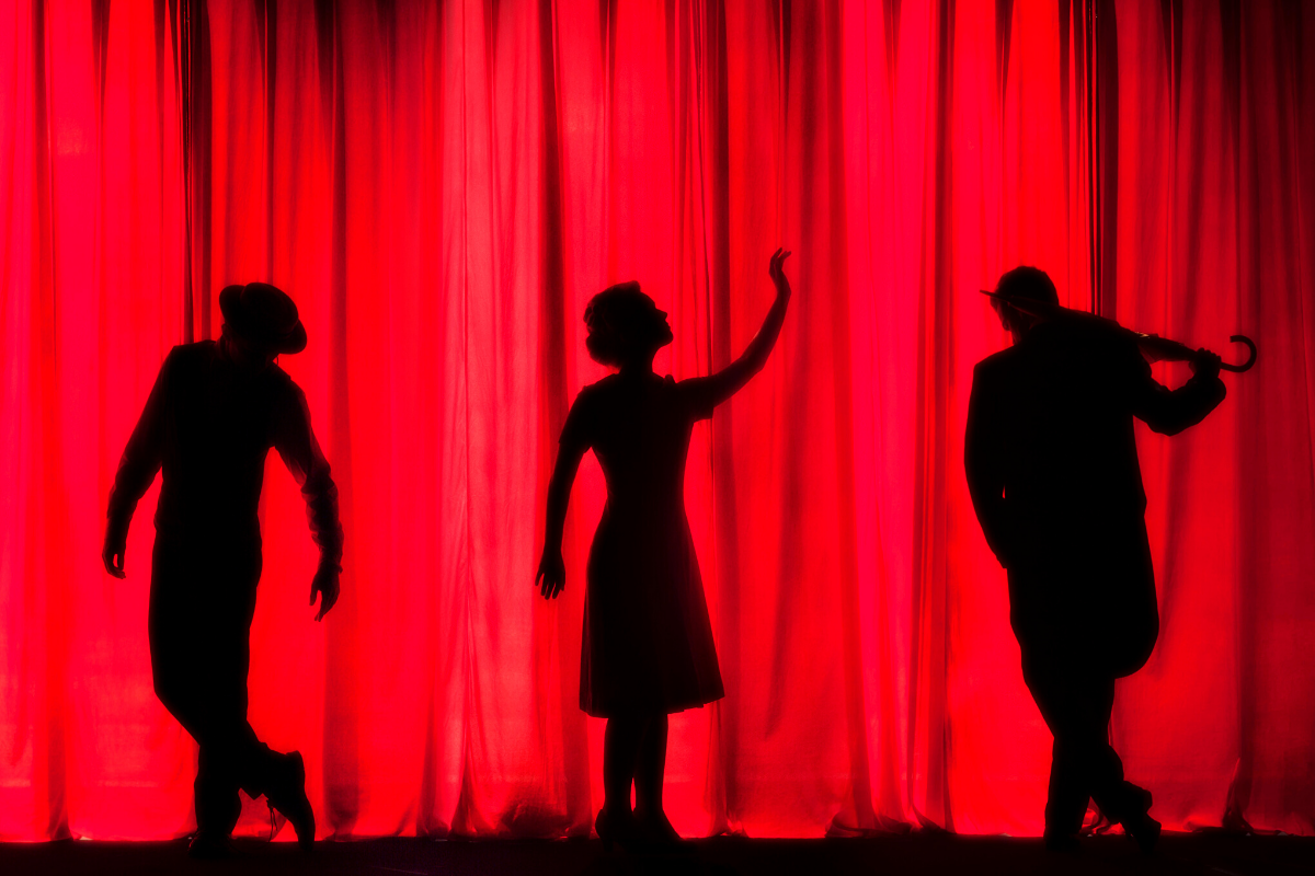 People in Front of a Theatre Curtain